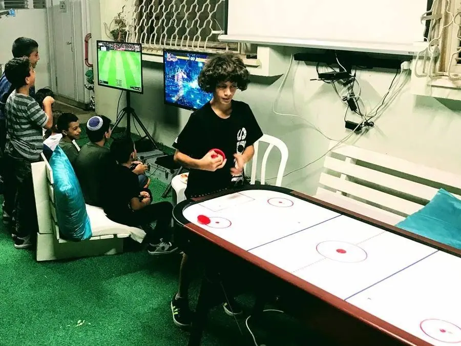 נער משחק הוקי אוויר וחברים משחקים בעמדות מולטימדיה
